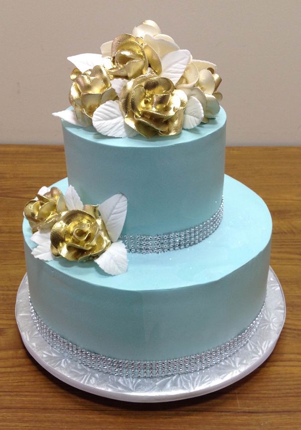 Two-tier blue cake with gold roses, made at Irene's